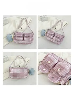 Detail view of pink plaid corduroy underarm bag with pockets and star plush keychain