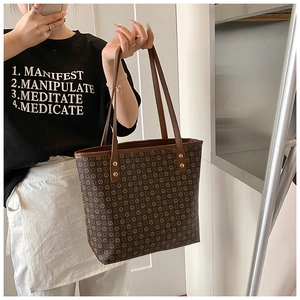 Detail of vintage tote bag featuring repeating circular patterns and gold hardware studs