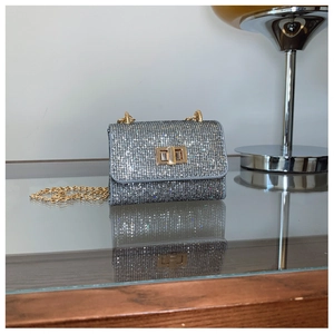 Détail du mini sac strass argenté avec chaîne dorée et fermoir pivotant en métal