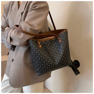 Detail of vintage tote bag with geometric print, brown handles and golden rivets
