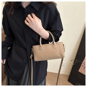 Dettaglio della borsa retrò kaki con scritta FASHION a rilievo e tracolla sottile