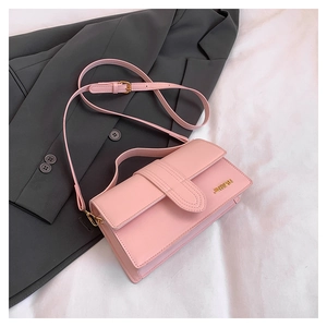 Detail of light pink leather crossbody bag showing magnetic flap and adjustable strap