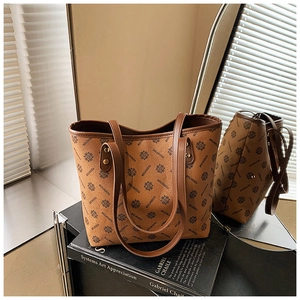 Detailed macro view of vintage brown monogram tote bag with gold rivets and leather trim