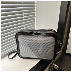 Détail de la bandoulière minimaliste noire avec panneau en mesh et garniture argentée