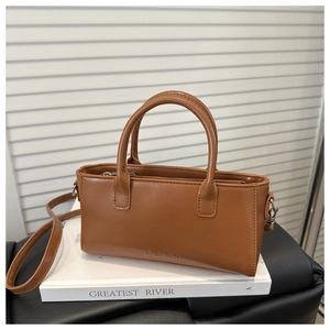 Dettaglio di una borsa marrone con incisione FASHION e tracolla regolabile elegante