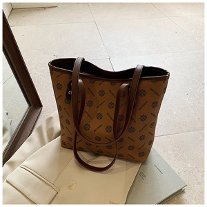 Detail of vintage patterned tote bag featuring a leather texture and brown shoulder straps