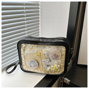 Détail du sac ita noir avec fenêtre PVC montrant des badges anime et dentelle