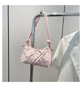 Detail der rosa Denim-Schultertasche mit Fransen-Textur und geknotetem Lederriemen