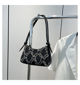 Detail der schwarzen Denim-Patchwork-Tasche mit Fransen und geknoteten Schultergurten