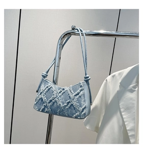 Detailansicht der hellblauen Denim-Achseltasche mit ausgefranster Rautensteppung