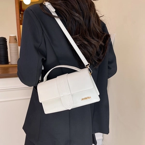 Minimalist white rectangular shoulder bag with top handle and gold logo detail