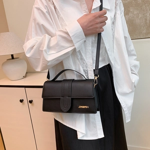 Minimalist black rectangle crossbody bag with top handle and gold logo for women