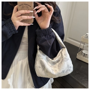 Détail de la texture jacquard papillon argenté sur ce sac hobo chic porté épaule pour femme