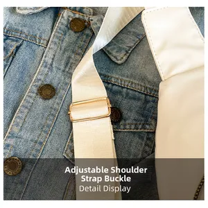 Close-up of adjustable strap buckle in gold on white crossbody bag with denim backdrop