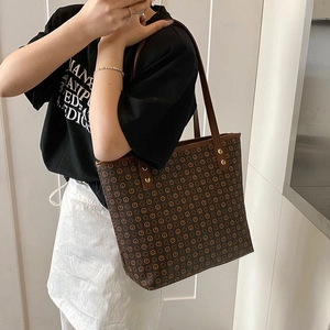 Large retro tote bag with monogram print and golden studs for daily commute and travel