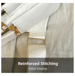 Close-up of white faux leather bag with reinforced stitching and gold metal hardware