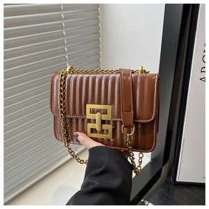 Détail du sac matelassé marron montrant le cuir brillant et la boucle en métal doré