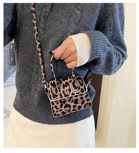 Mini leopard print crossbody bag detail shown on a model with adjustable strap and flap