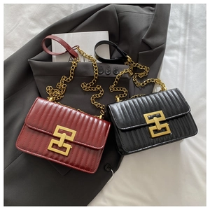 Détail de sacs en cuir matelassé avec boucles dorées et bandoulières en chaîne