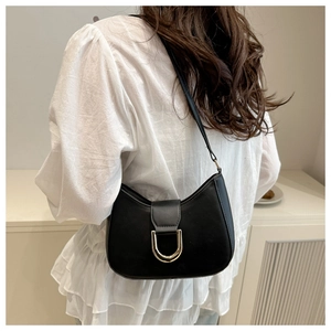 Chic black crescent underarm bag featuring a prominent gold horseshoe buckle detail