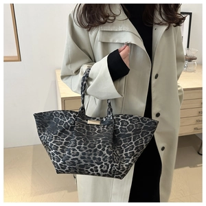 Detail of leopard print tote bag with golden metal buckle and spacious open top design