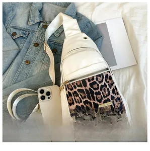 Detailed size comparison of white leopard print crossbody bag next to a smartphone