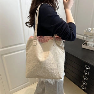 Minimalist nylon tote bag with drawstring closure in beige and pink for daily use