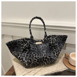Detail of the high-capacity leopard print tote bag with golden metal hardware accent