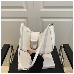 Close-up of white leather crescent shoulder bag with elegant gold D-ring buckle