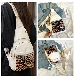 Detail view of leopard print crossbody bag with headphone port and zipper pockets