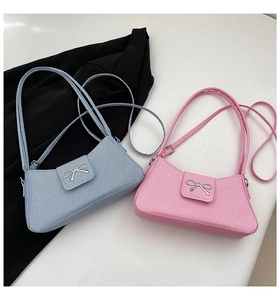 Detail of light blue and pink bow-tie baguette bags with twill fabric texture