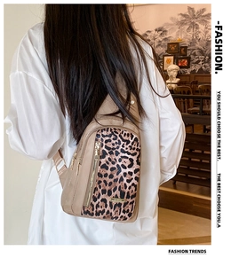 Fashionable leopard print crossbody bag worn by a model in a cozy cafe setting