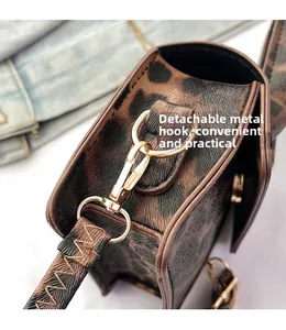 Detail of leopard print handbag showing gold metal hook and detachable strap