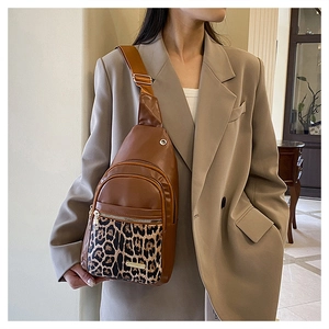 Close-up of leopard print pocket and adjustable wide strap on women's brown crossbody bag