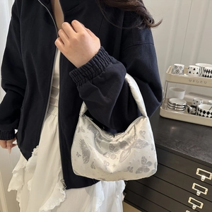 Sac croissant argenté avec jacquard papillon et fini satiné porté par un mannequin
