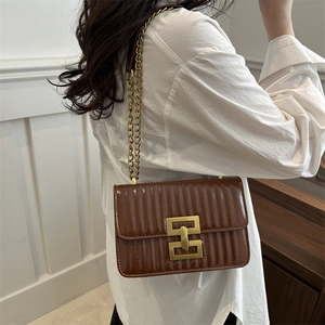 Sac bandoulière en cuir matelassé marron avec chaîne dorée et fermoir sur modèle