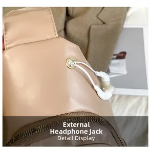 Detail view of the external earphone hole on a beige leopard print crossbody bag