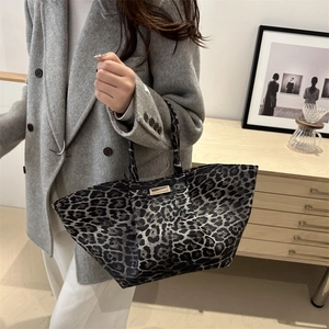 Stylish leopard print large capacity tote bag shown being held by a model in casual attire