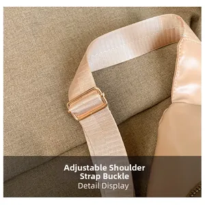 Detail showing adjustable beige nylon shoulder strap with light gold metal buckle