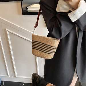 Sac seau minimaliste en paille à rayures noires avec une bandoulière en cuir marron