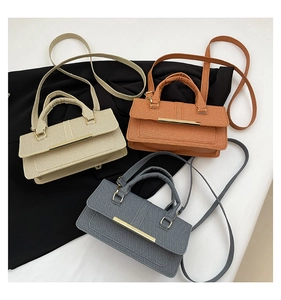 Detailed overhead view of minimalist textured fabric handbags in beige, orange, and blue