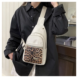 Detail of leopard print pocket on white canvas crossbody bag with wide shoulder strap