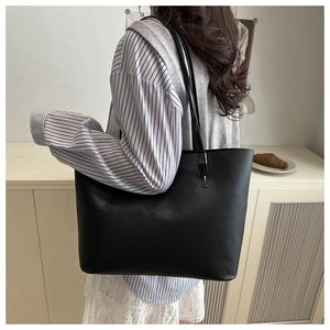 Vue détaillée de la texture du cuir fin et de la boucle en métal du sac cabas noir