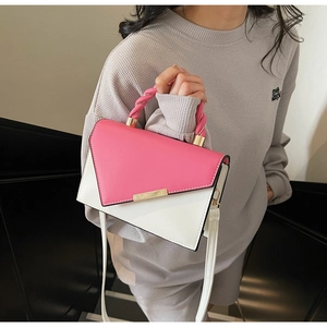 Detail of pink and white color-block handbag with woven handle and golden metal buckle