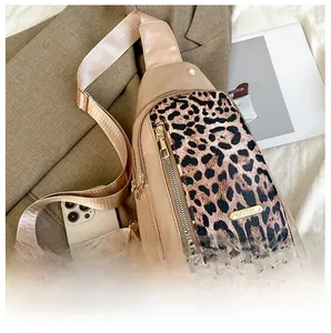 Detailed view of leopard print crossbody bag with size comparison to a mobile phone