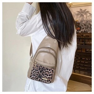 Beige leopard print crossbody chest bag with adjustable strap worn on the back