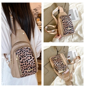 Detailed interior storage view of leopard print crossbody bag with multiple zippers
