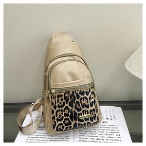 Detail of leopard print stitching and golden hardware on a beige PU leather chest bag