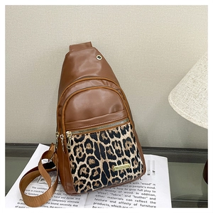 Detailed view of brown PU leather bag featuring leopard print pocket and gold zippers