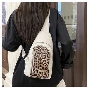 Detail of stylish white chest bag with leopard print panel and gold metal hardware finish